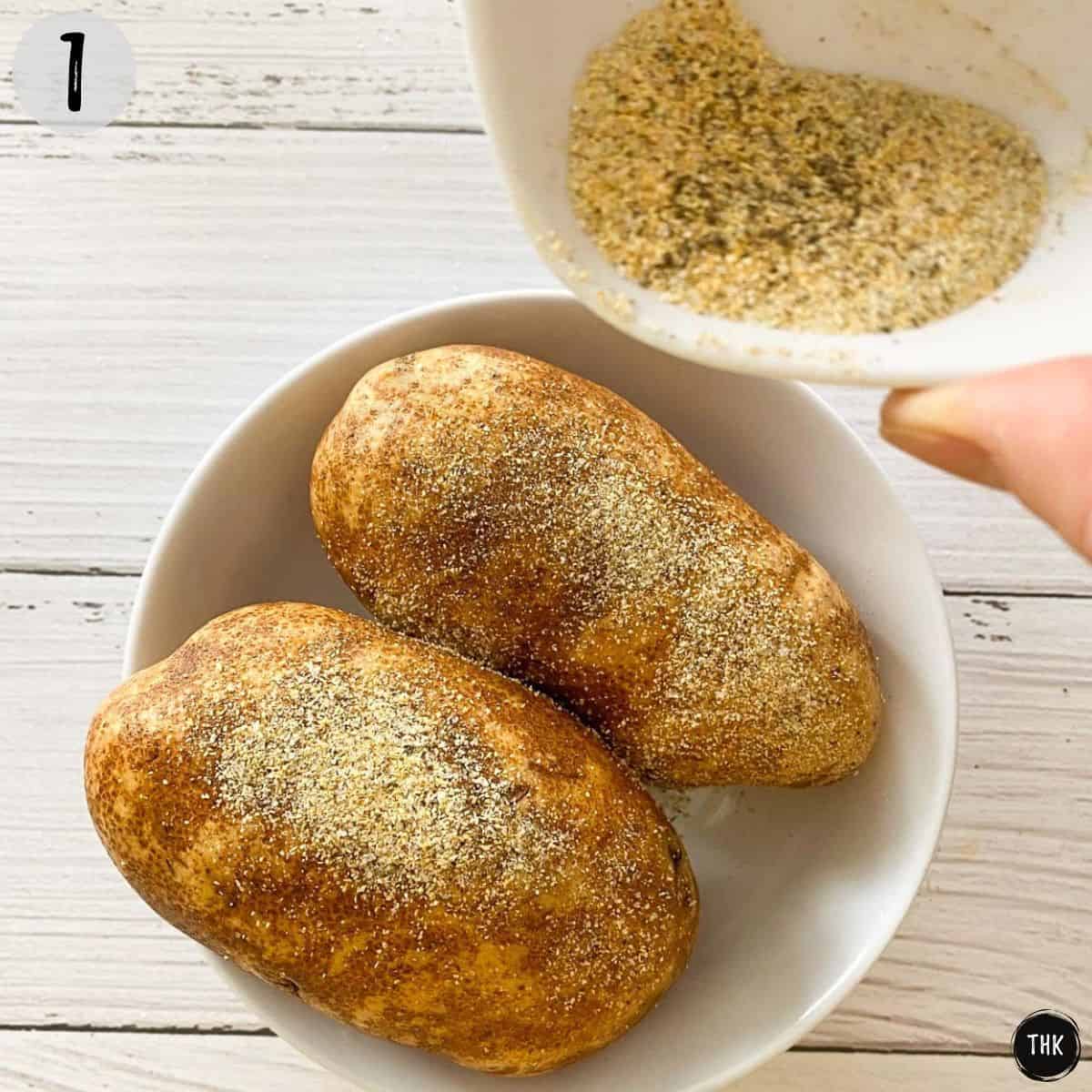 Seasoning being sprinkled on russet potatoes.