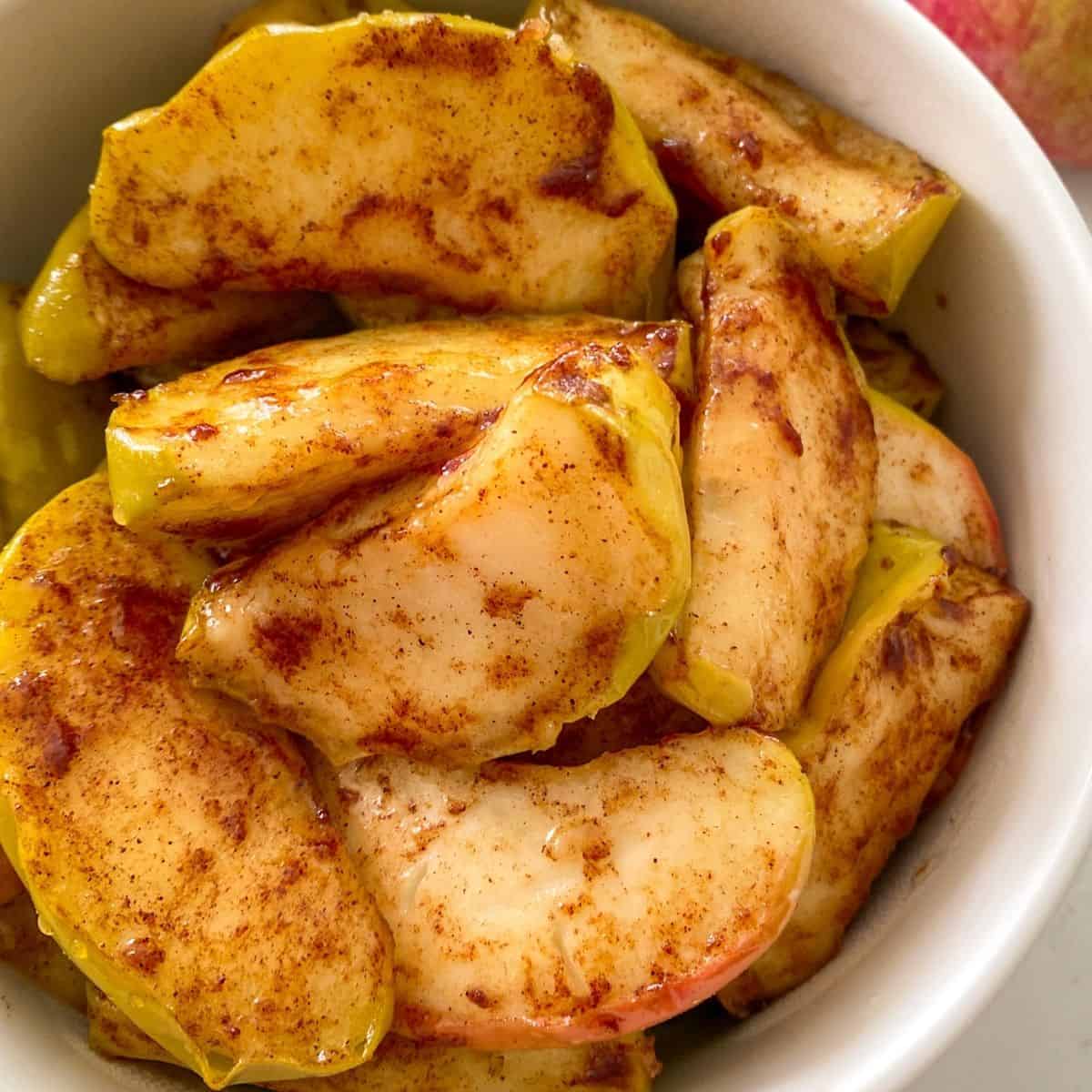 Close up of baked apples in white serving dish.
