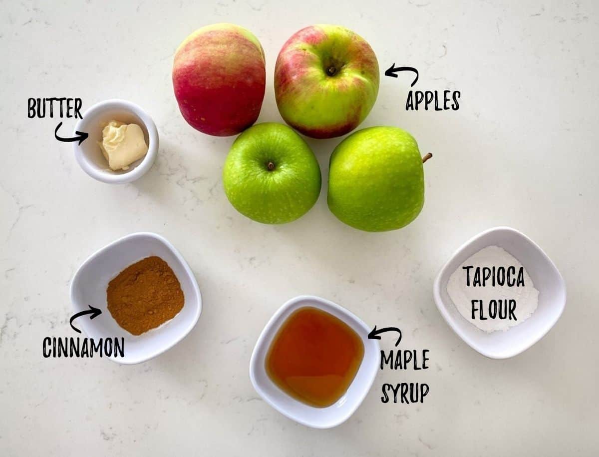 Apples, butter, syrup, cinnamon and flour on kitchen counter.