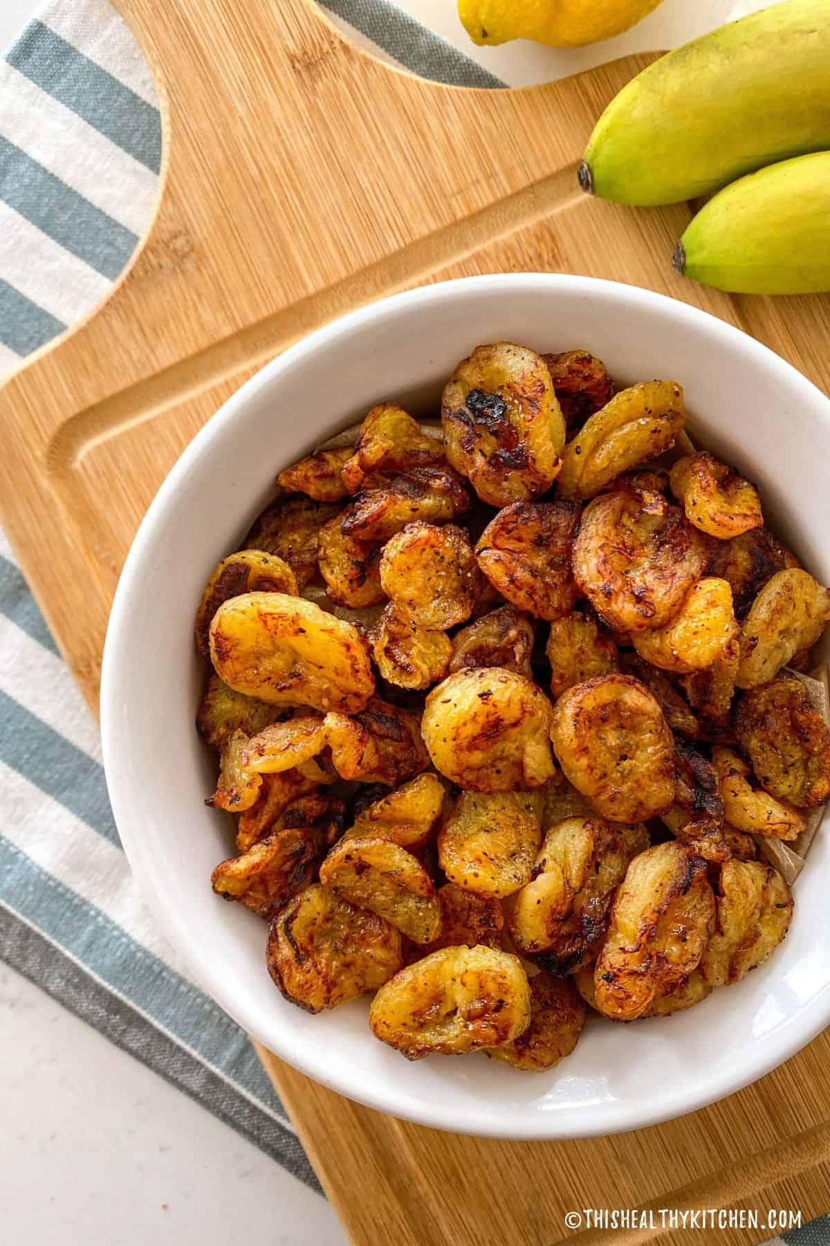 White bowl filled with air fried banana slices.