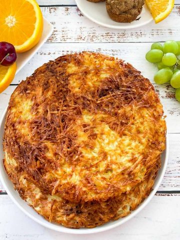 plate with large hash browns and fruit scattered around the dish