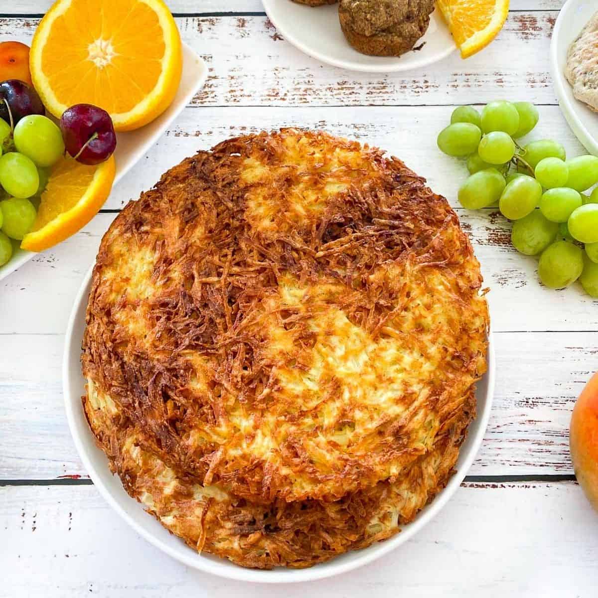 plate with large hash browns and fruit scattered around the dish