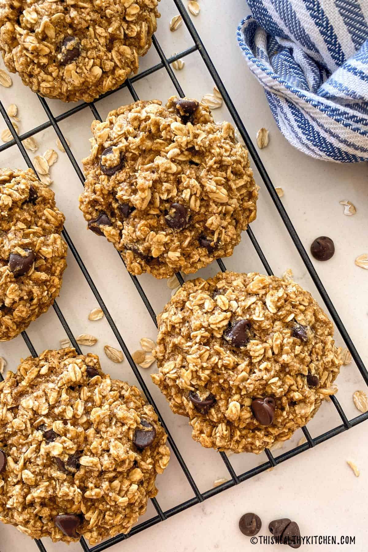 Oatmeal cookies with chocolate chips on cooling rack.