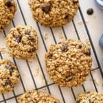 Oatmeal cookies with chocolate chips on cooling rack.