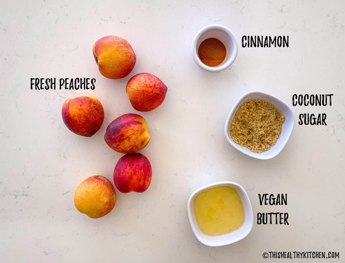 Peaches, cinnamon, sugar and button on kitchen counter top.