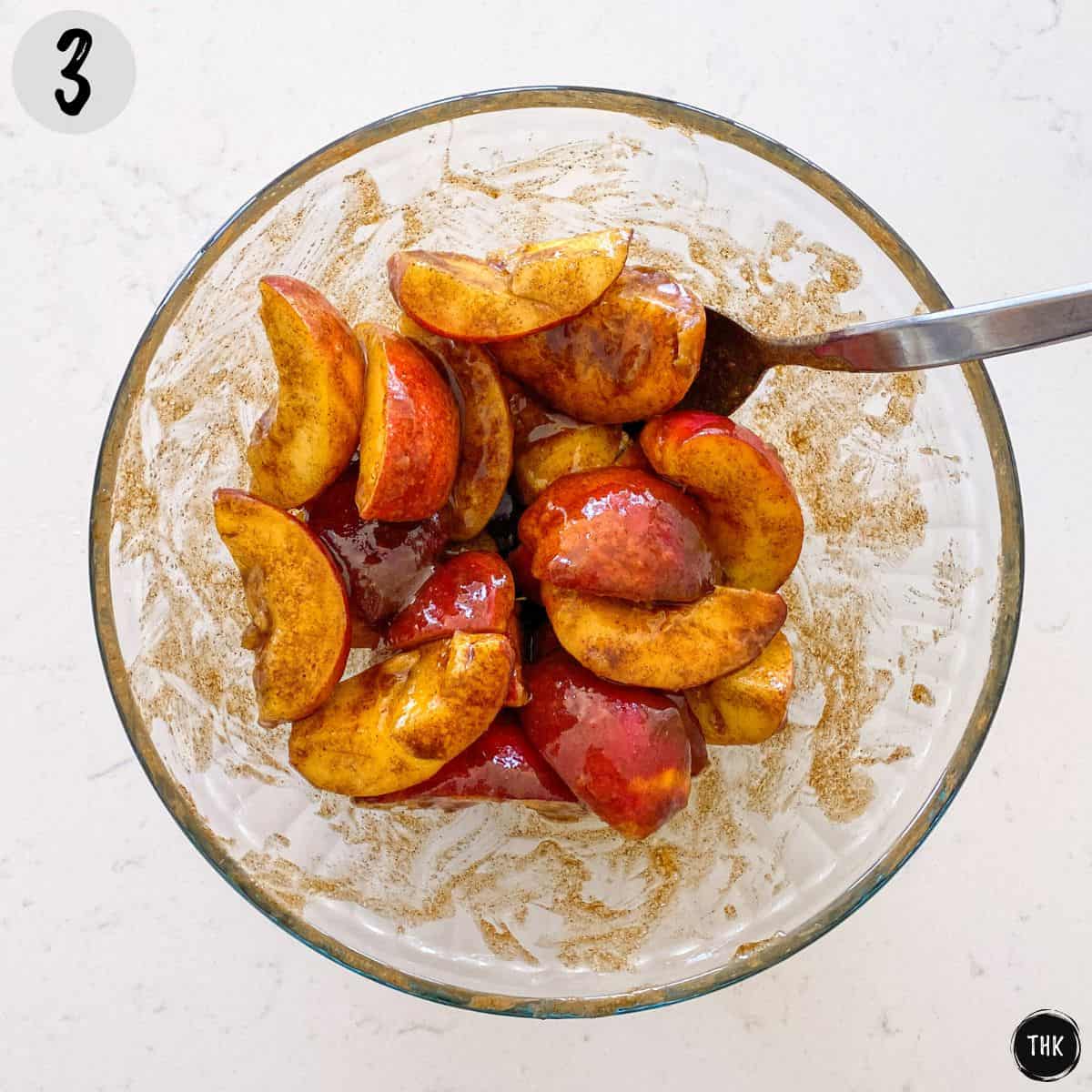 Sliced peaches with sugary mixture on top.