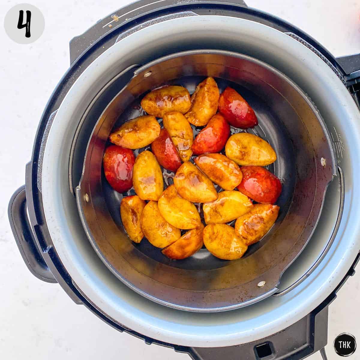 Peach slices in basket of air fryer.