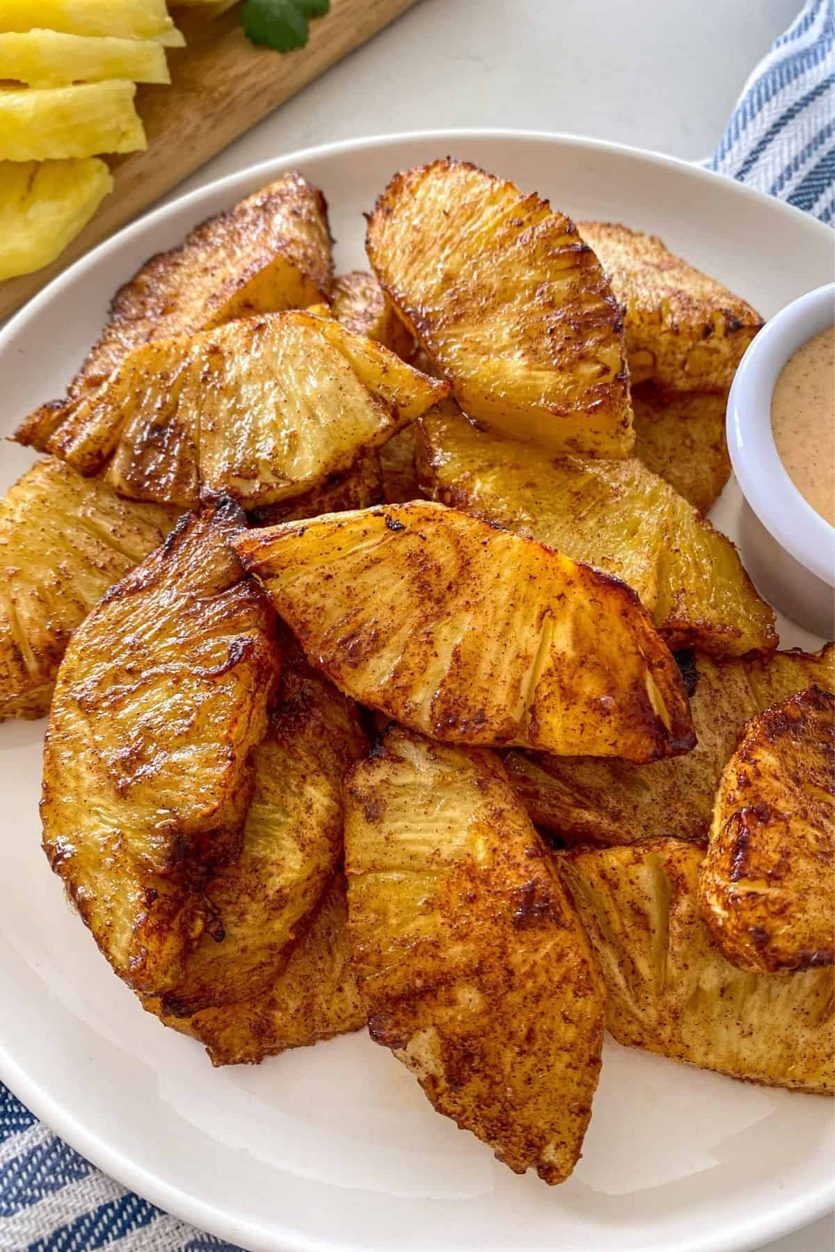 Roasted pineapple slices on white plate.