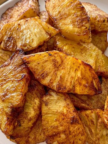 Roasted pineapple slices on white plate.
