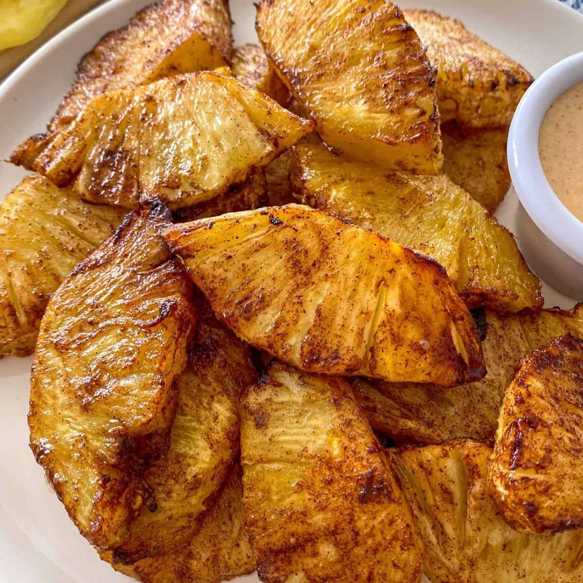 Roasted pineapple slices on white plate.