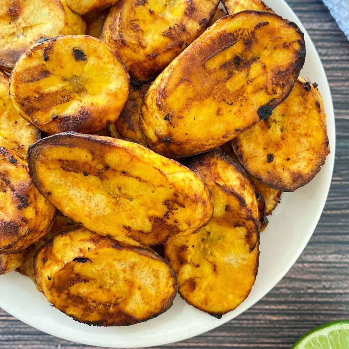 White plate with air fried plantain chips inside.