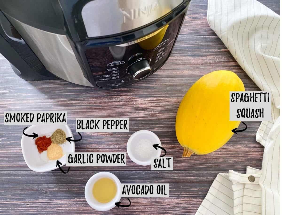 ingredients required to make air fryer spaghetti squash scattered on brown deck.