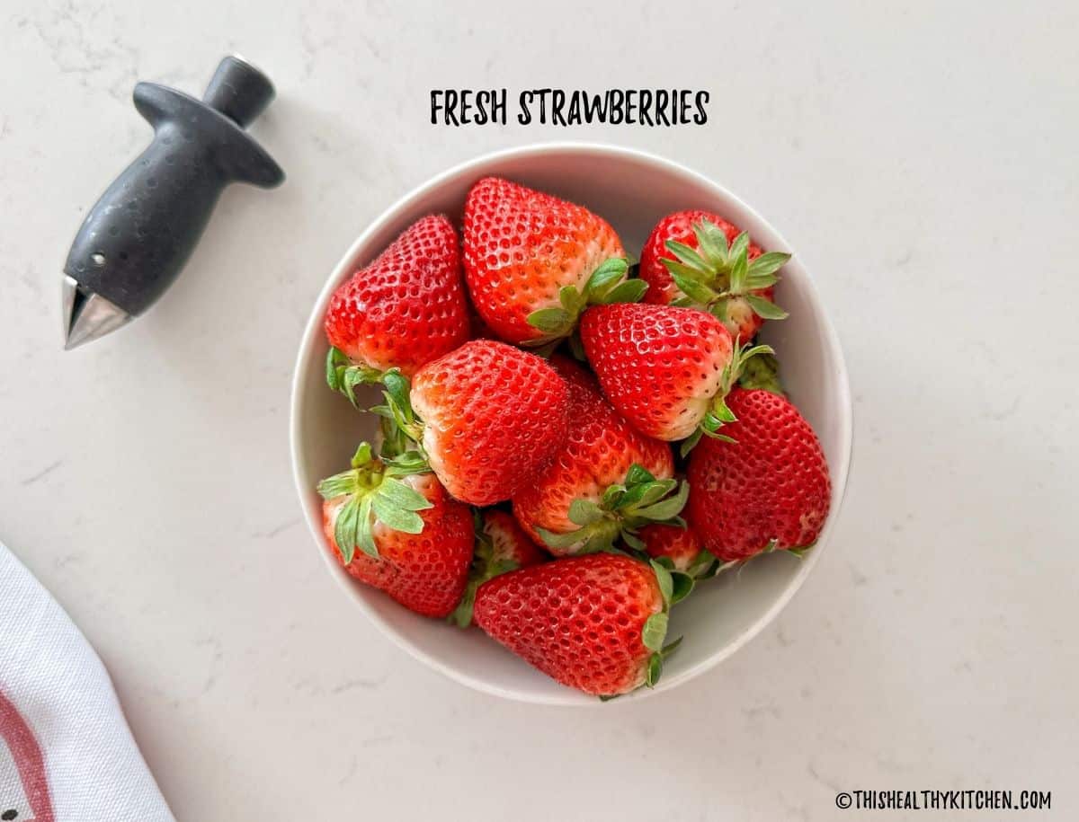 Bowl of fresh strawberries on kitchen counter top.