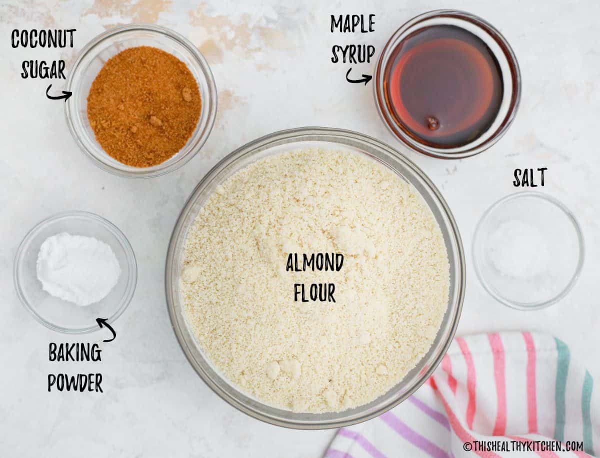 Bowls of almond flour, sugar, maple syrup, salt and baking powder.