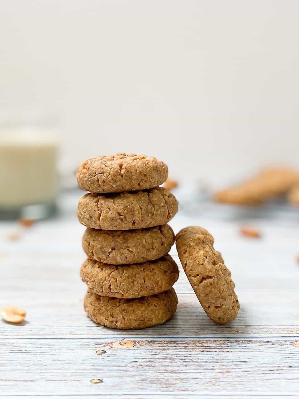 5 cookies stacked in a tower with 1 cookie leaning on its side against them