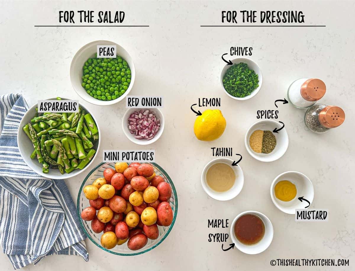 Mini potatoes, peas, asparagus, red onion, chives, spices, maple syrup, mustard and lemon in prep bowls on countertop.