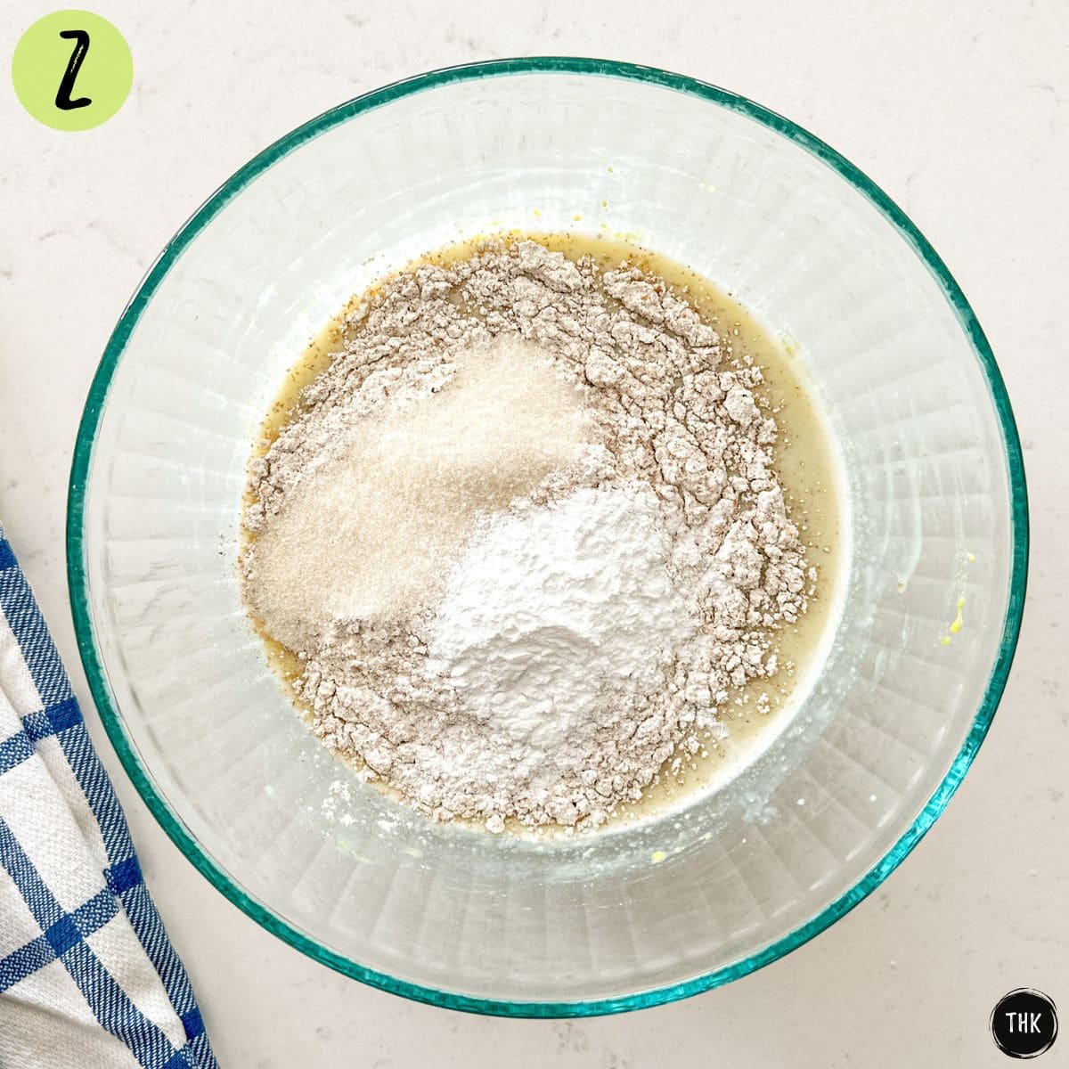 Large glass bowl with pancake batter ingredients inside.