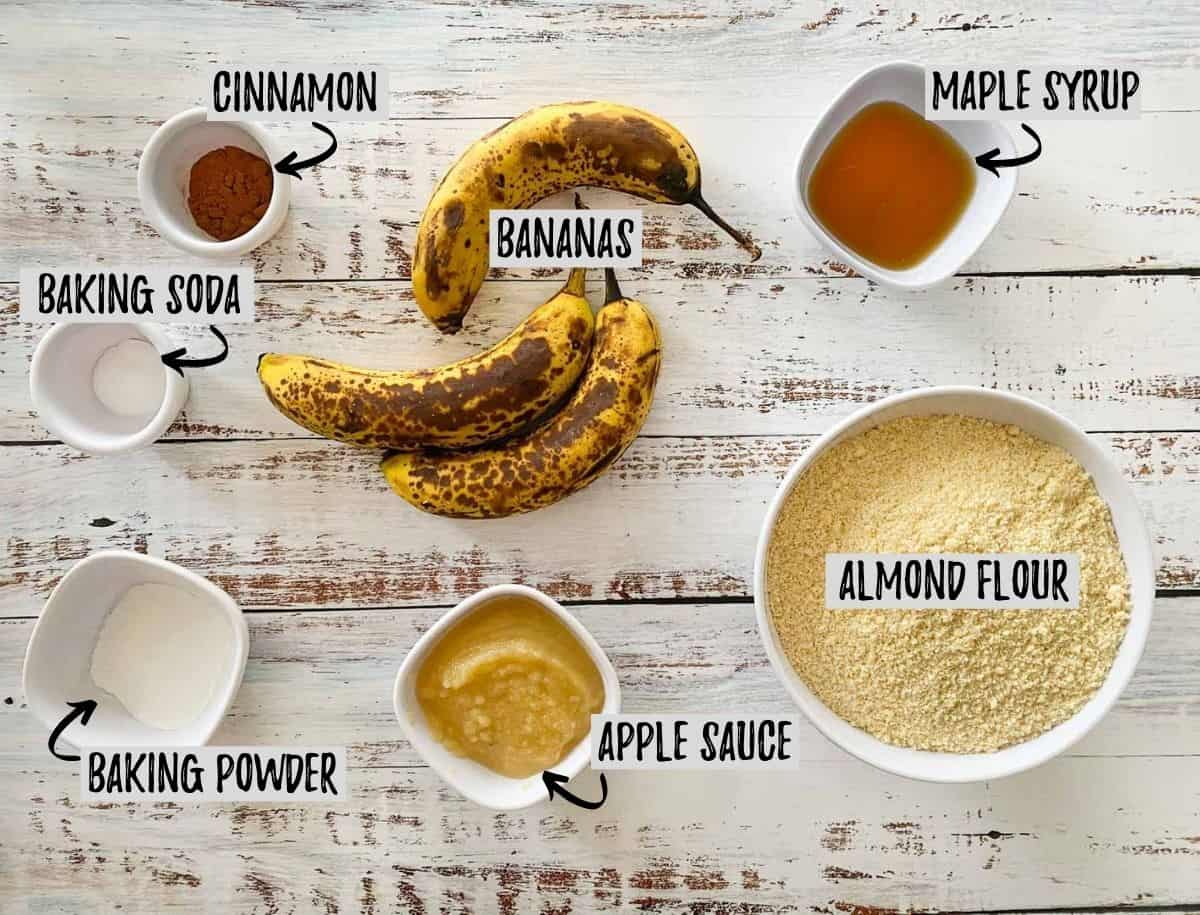 Bowl of almond flour, ripe bananas, and small prep bowls on white deck.