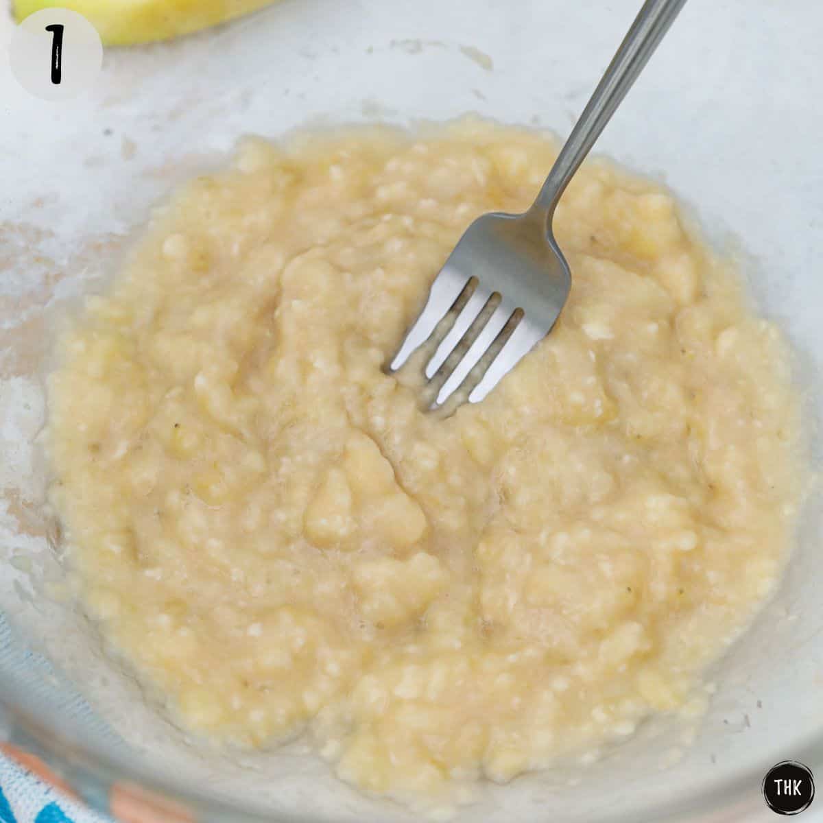 Mashed banana inside mixing bowl.