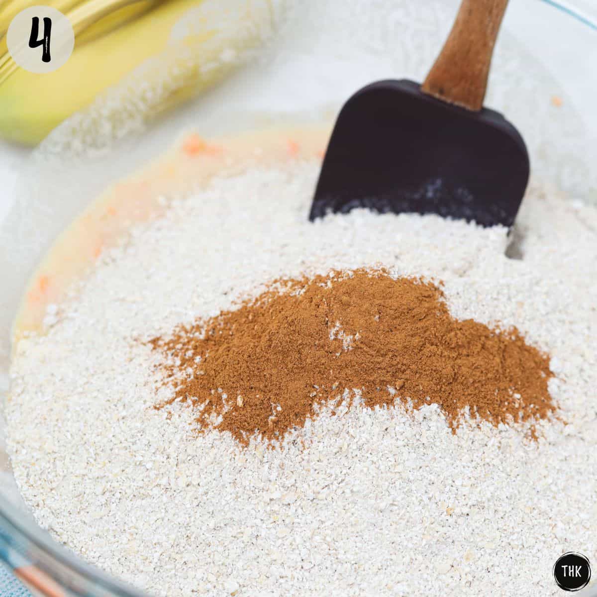 Flour and cinnamon added to bowl with wet batter.
