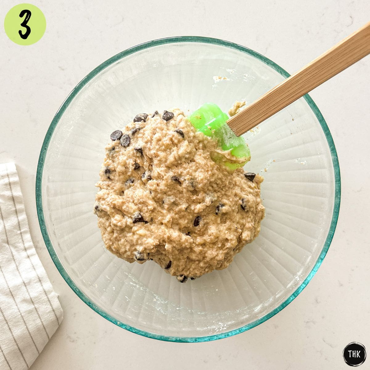 Cookie dough batter with chocolate chips in large glass bowl.