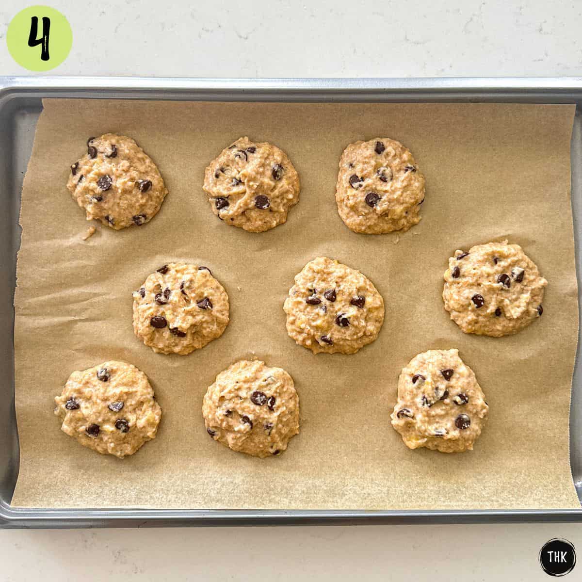 Chocolate chip cookies on baking sheet lined with parchment paper.