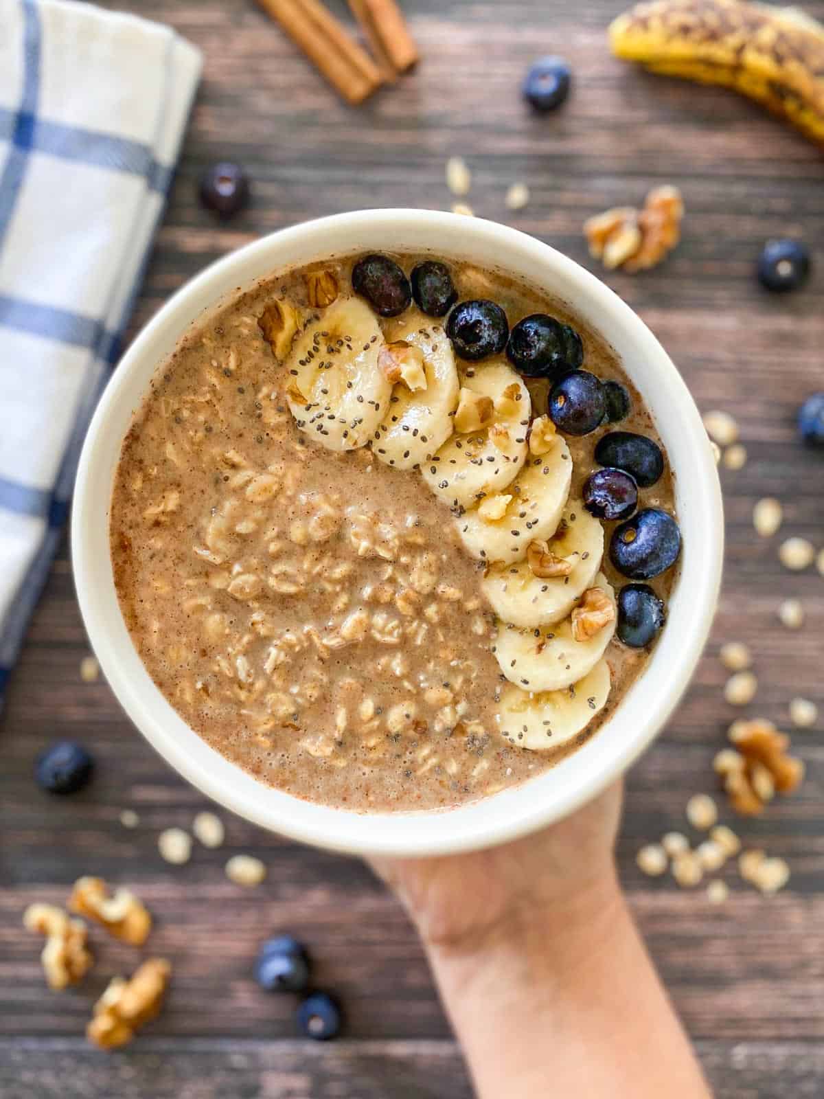 Bowl of oatmeal with banana slices and blueberries on top.