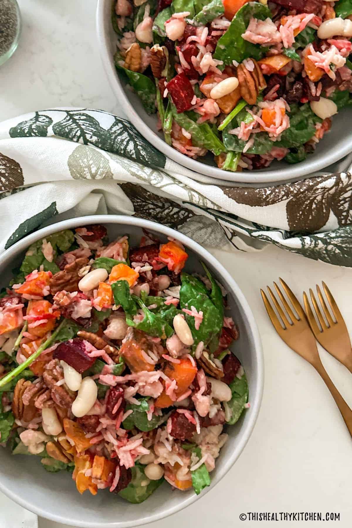 Salad with beets, sweet potato, rice, white beans, spinach, pecans and tahini dressing.