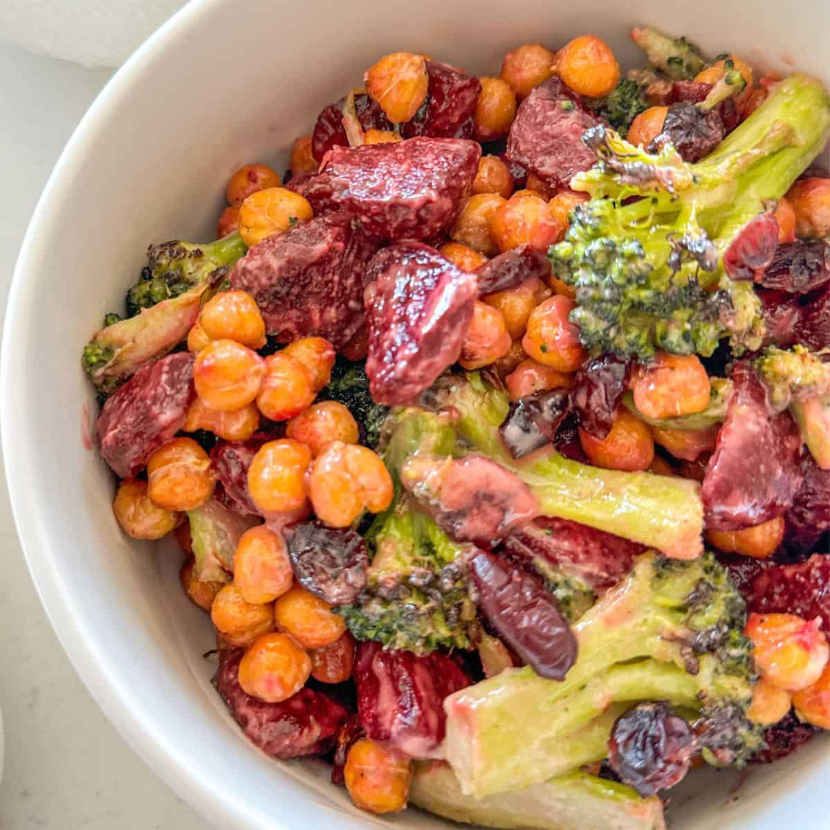 Broccoli and beetroot salad in white bowl.