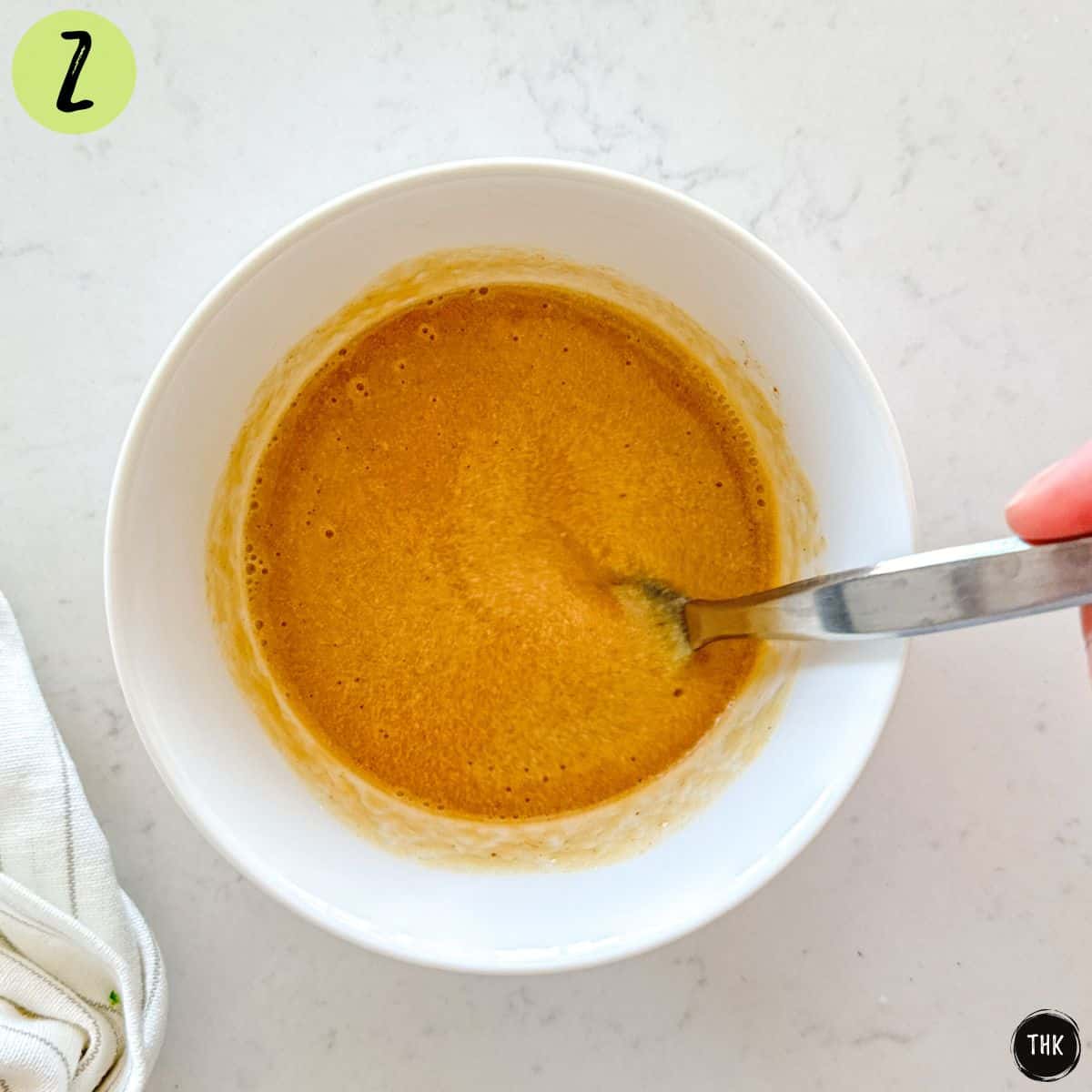 Salad dressing being mixed in small bowl.
