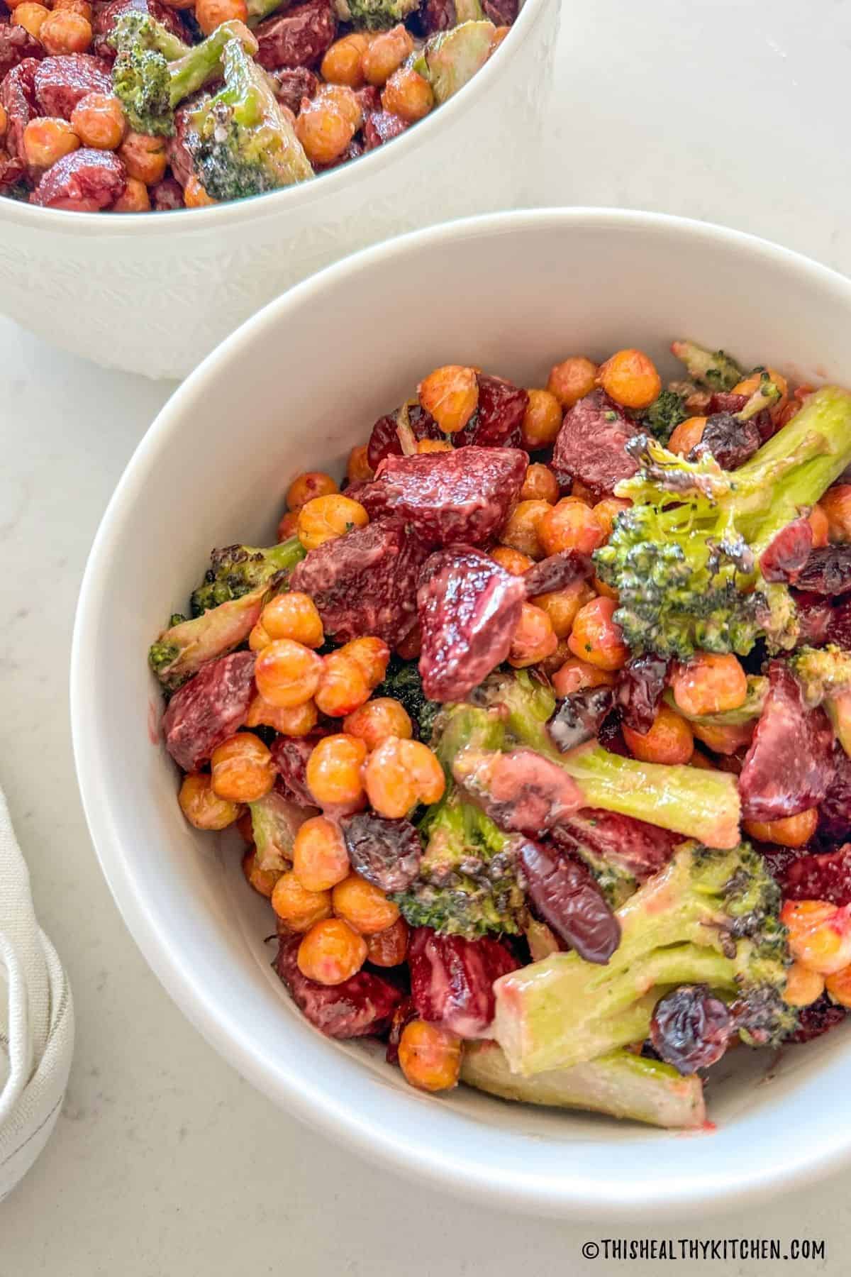 Two bowls of broccoli, beet and chickpea salad.
