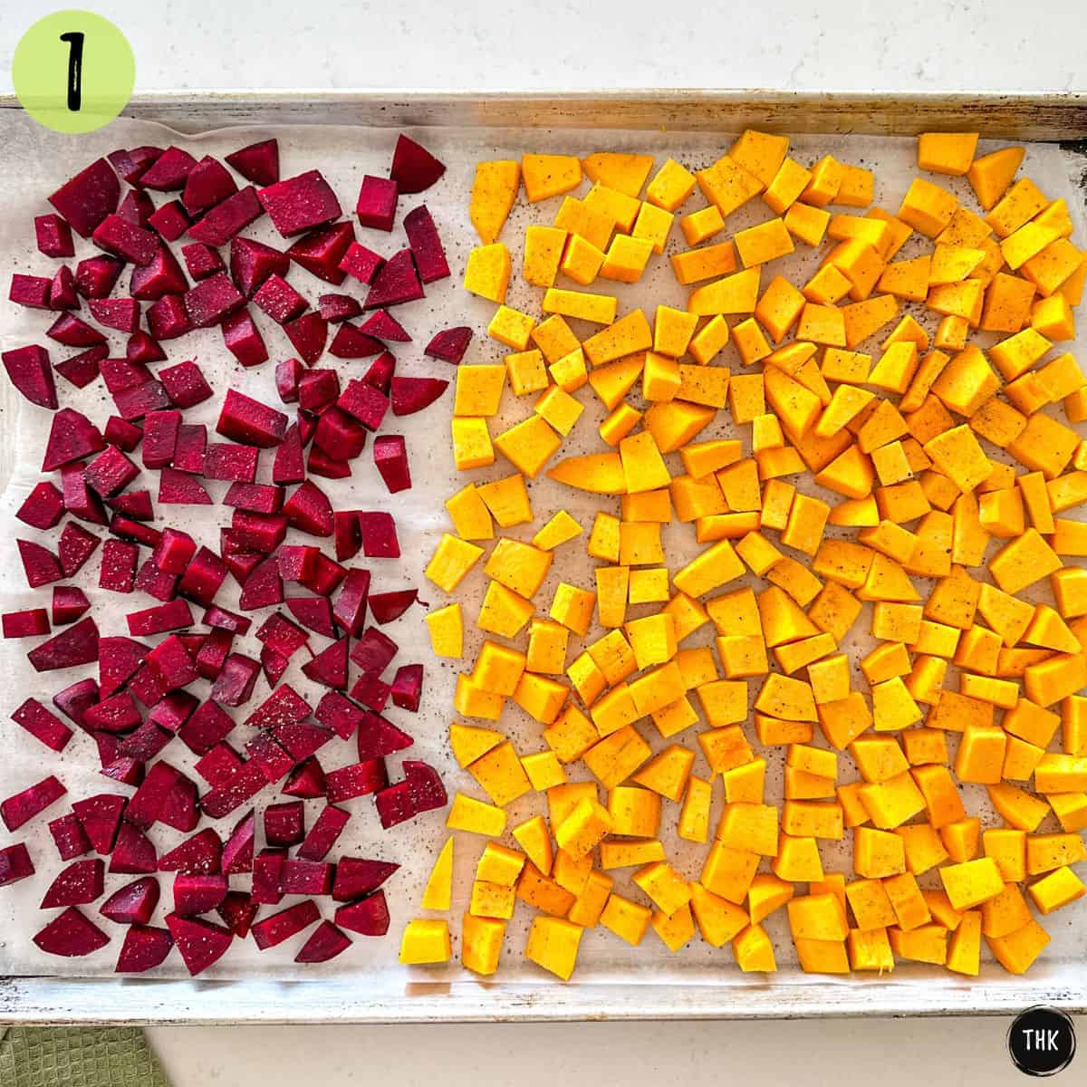 Cubed beets and cubed pumpkin pieces on baking sheet.