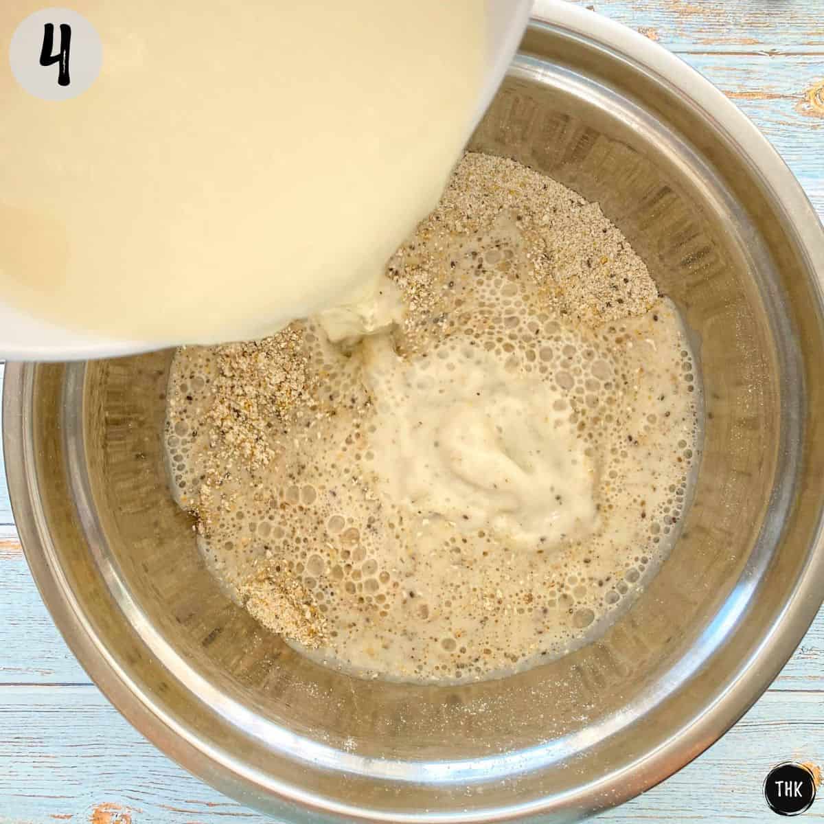 Milk being poured into bowl of dry ingredients.