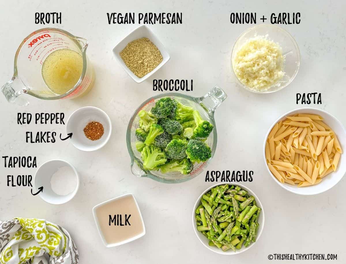 Ingredients needed to make broccoli asparagus pasta on kitchen countertop.