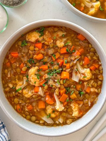 Close up of cauliflower and lentil soup in large bowl.