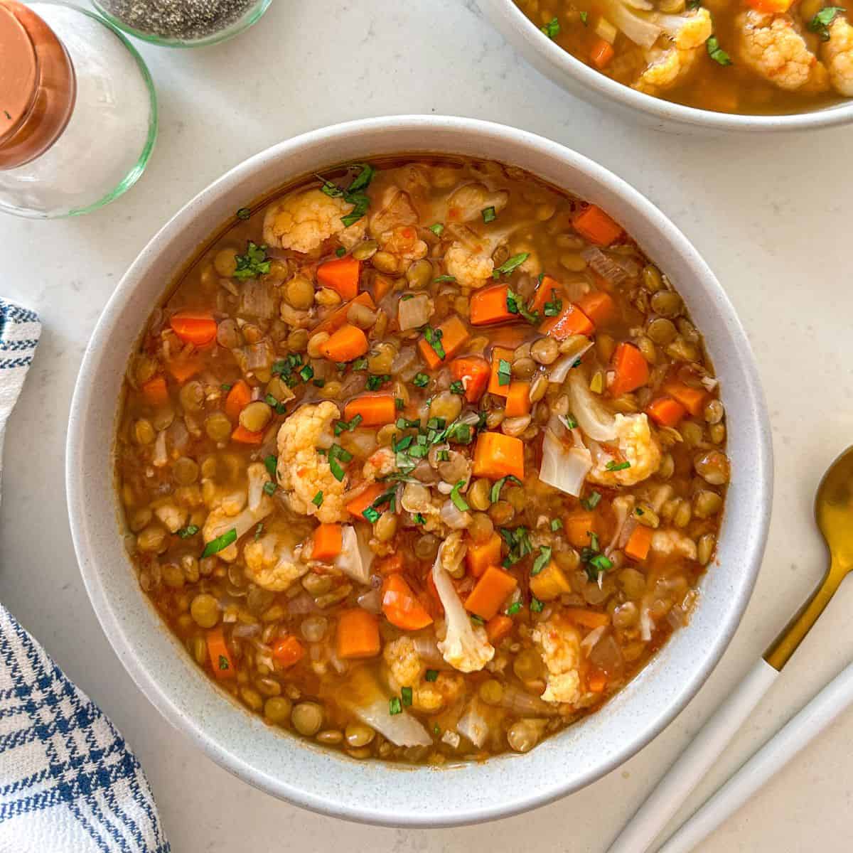 Close up of cauliflower and lentil soup in large bowl.