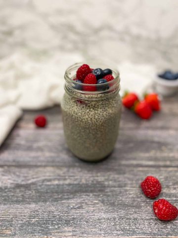 chia pudding in glass mason jar with fresh berries on top