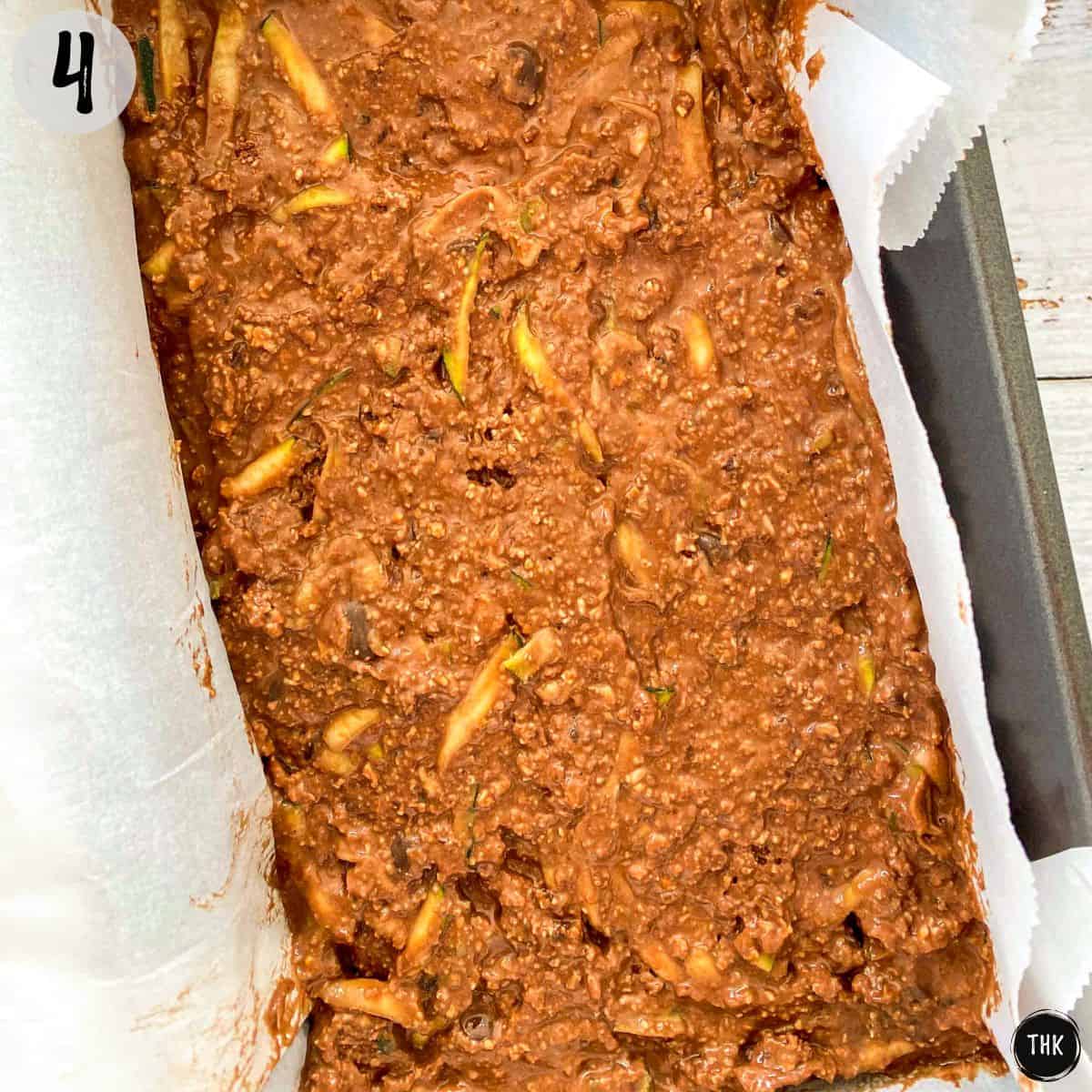 Chocolate zucchini bread batter inside loaf tin before baking.