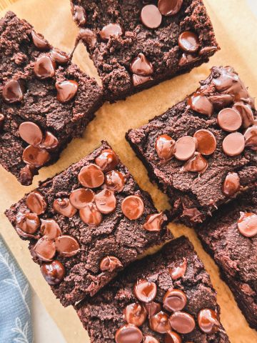 Chocolate cake squares with chocolate chips on cutting board.