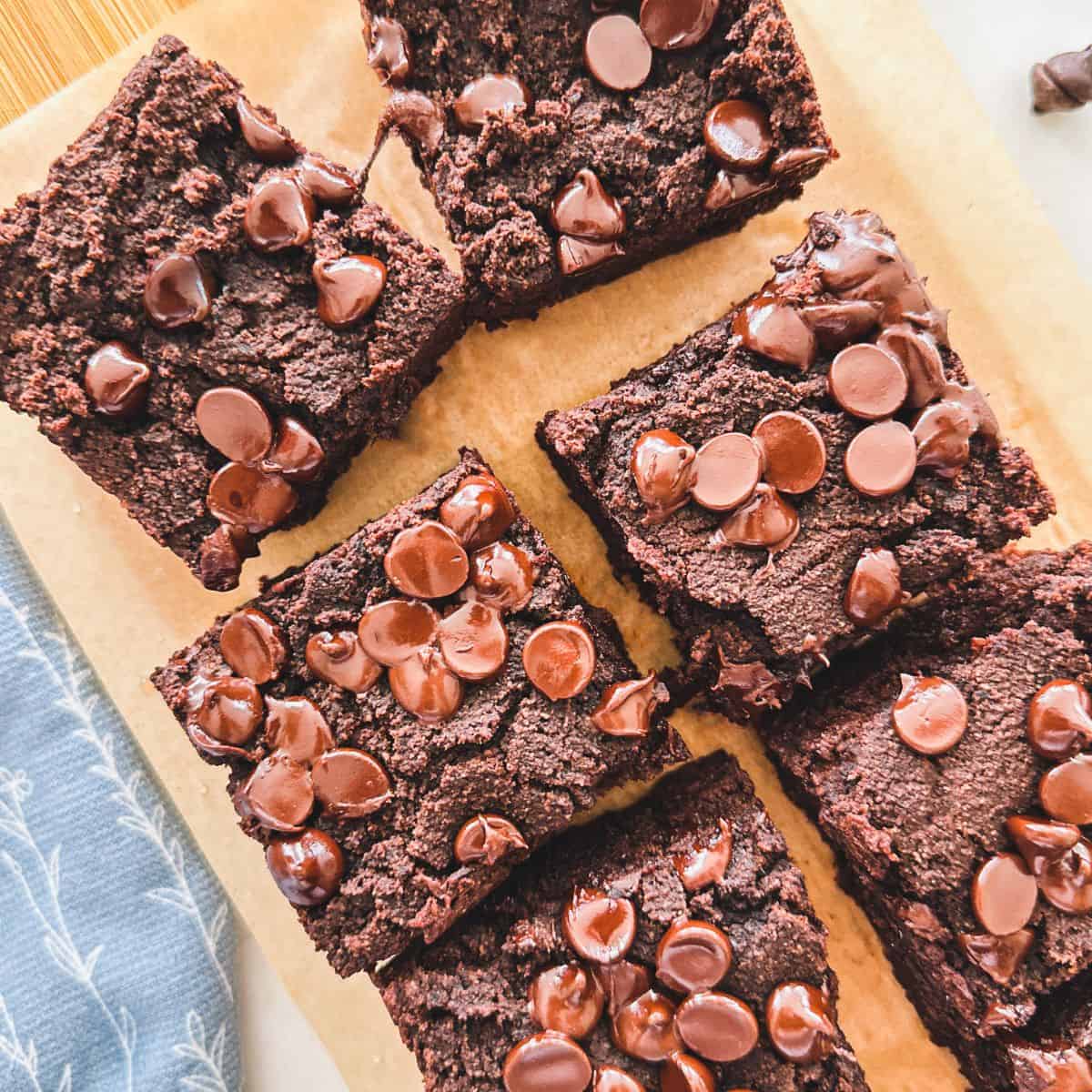 Chocolate cake squares with chocolate chips on cutting board.