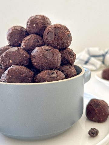 Double chocolate bliss balls stacked inside blue serving bowl.