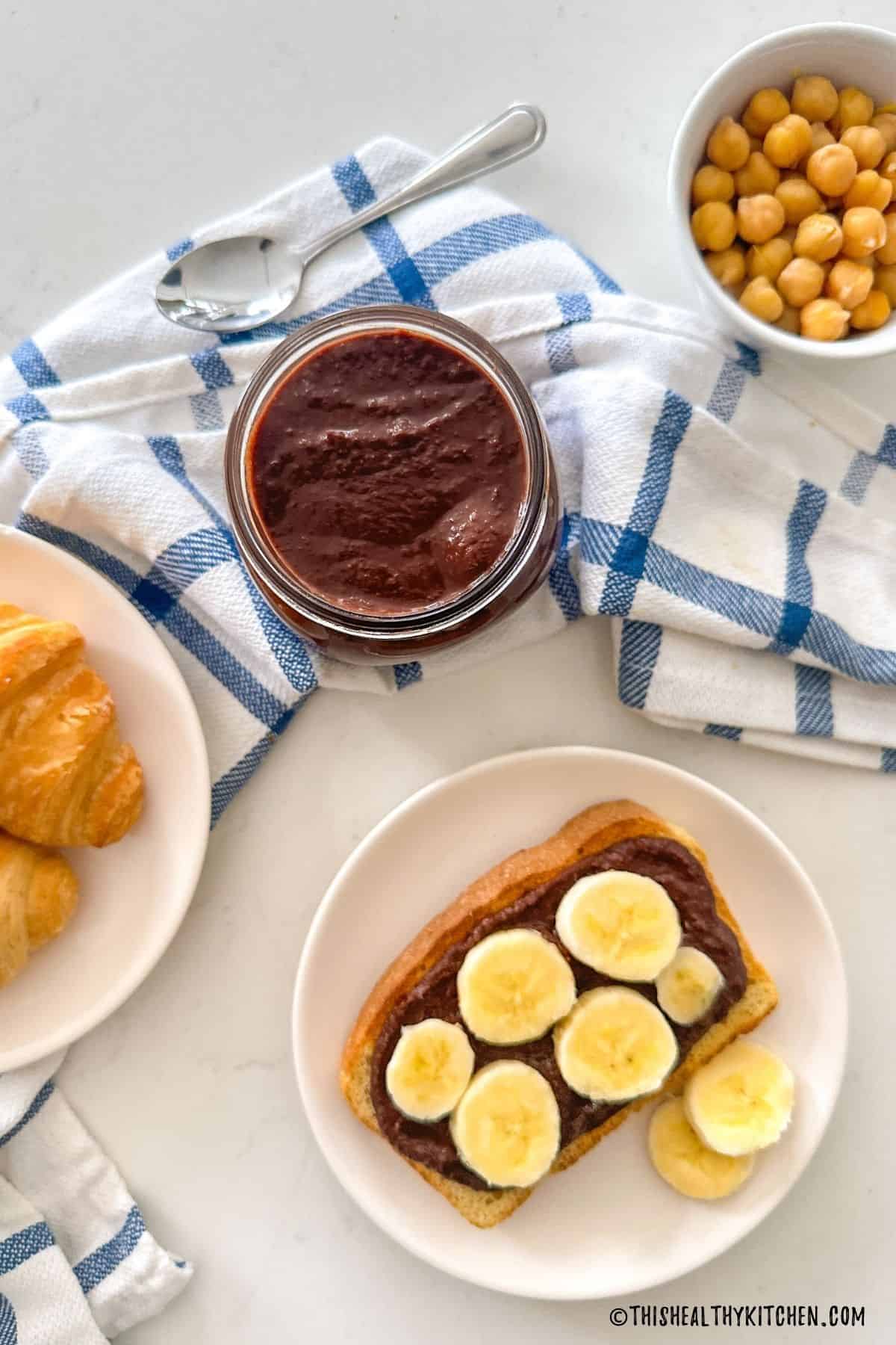 Jar of nut-free nutella with toast and chickpeas beside it.