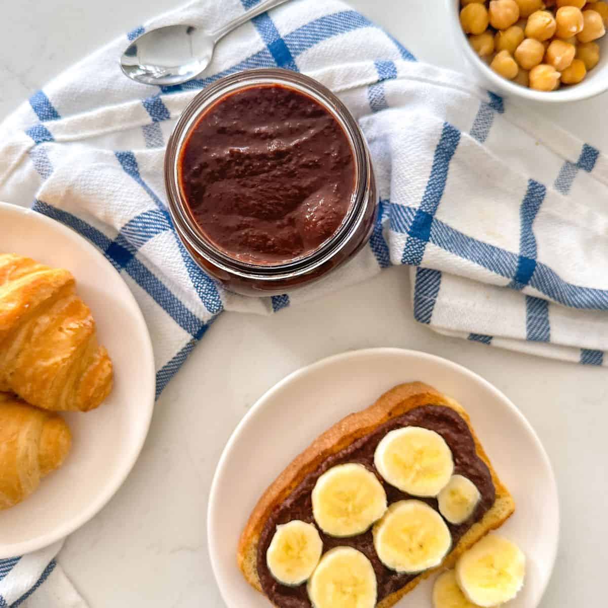 Jar of nut-free nutella with toast and chickpeas beside it.