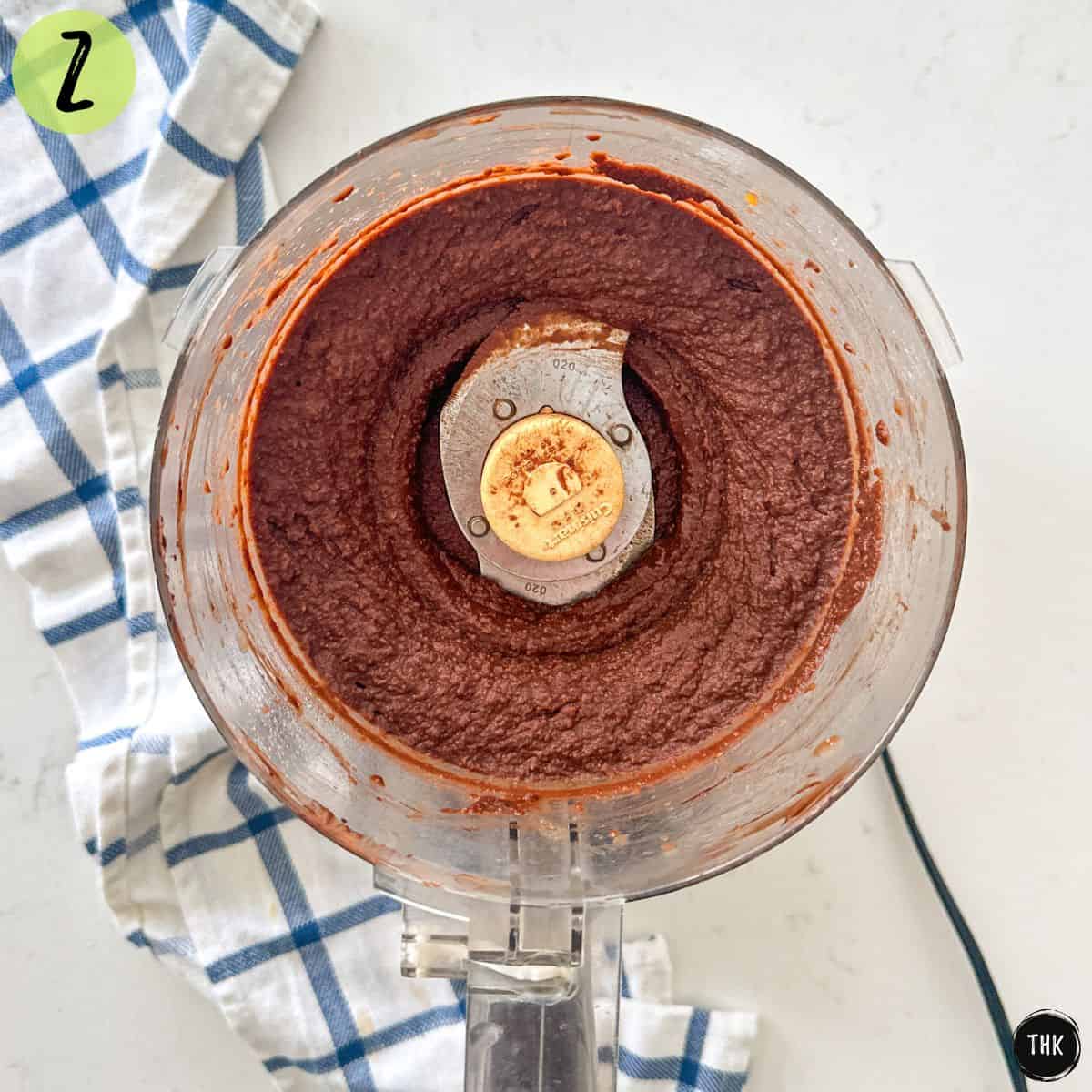 Food processor bowl with chocolate chickpea spread inside.