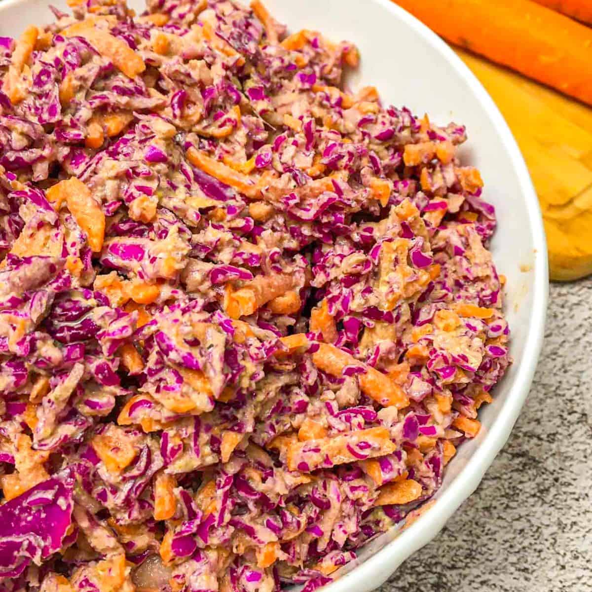White bowl with coleslaw inside.
