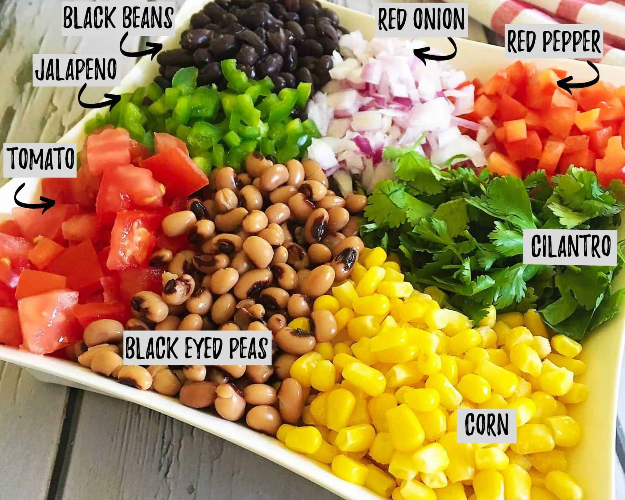 ingredients to make cowboy caviar: beans, tomato, corn, cilantro, red pepper, jalapeno, red onion