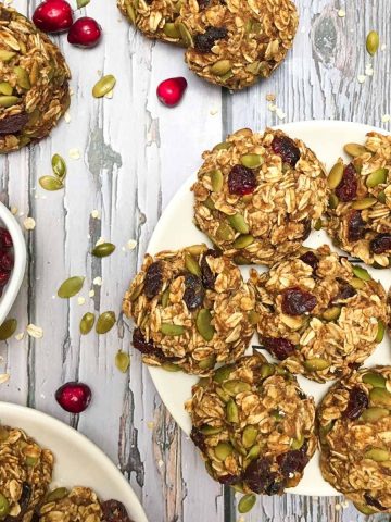 plate of oatmeal cranberry cookies on grey deck.
