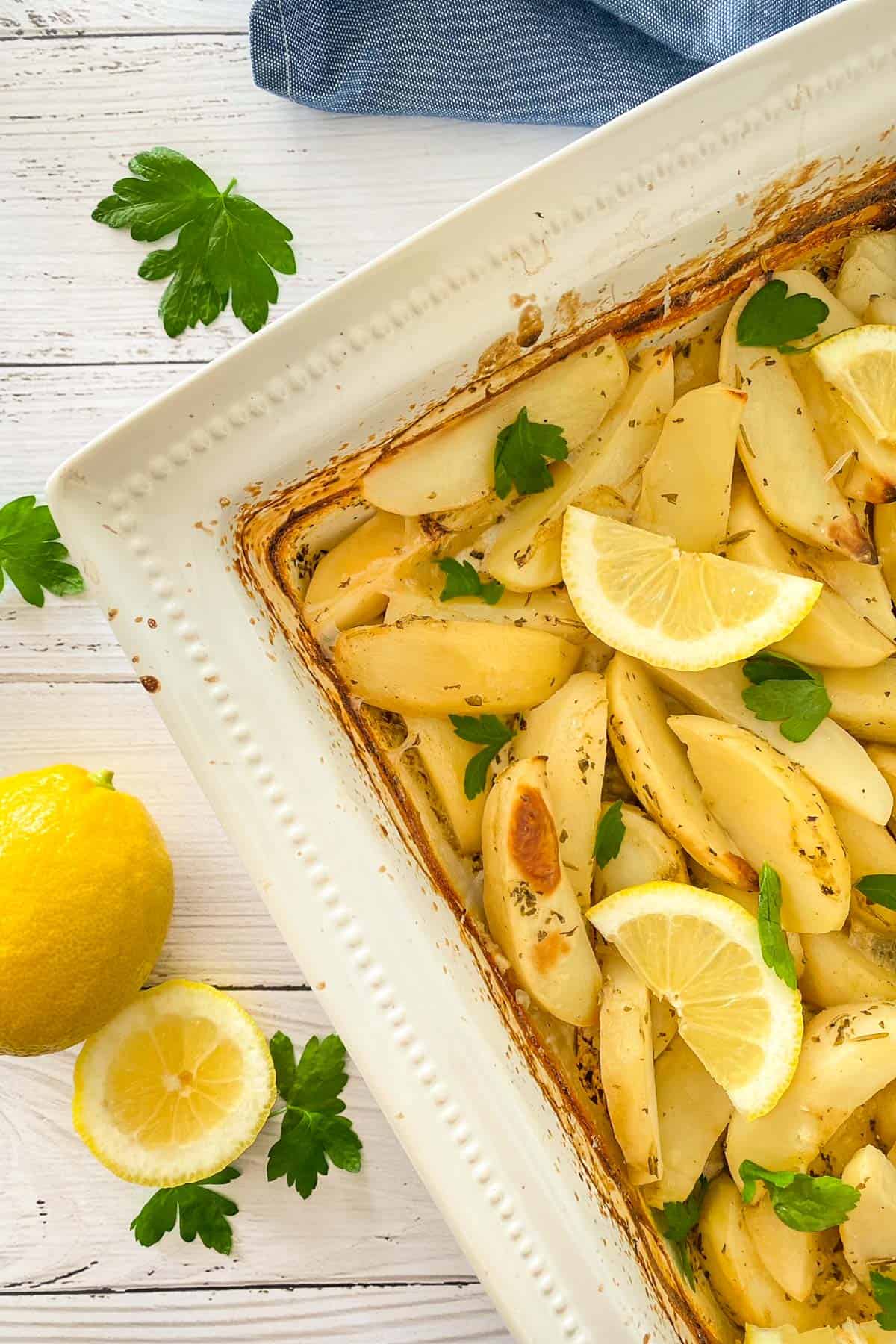 Roasted potato wedges in white baking dish.
