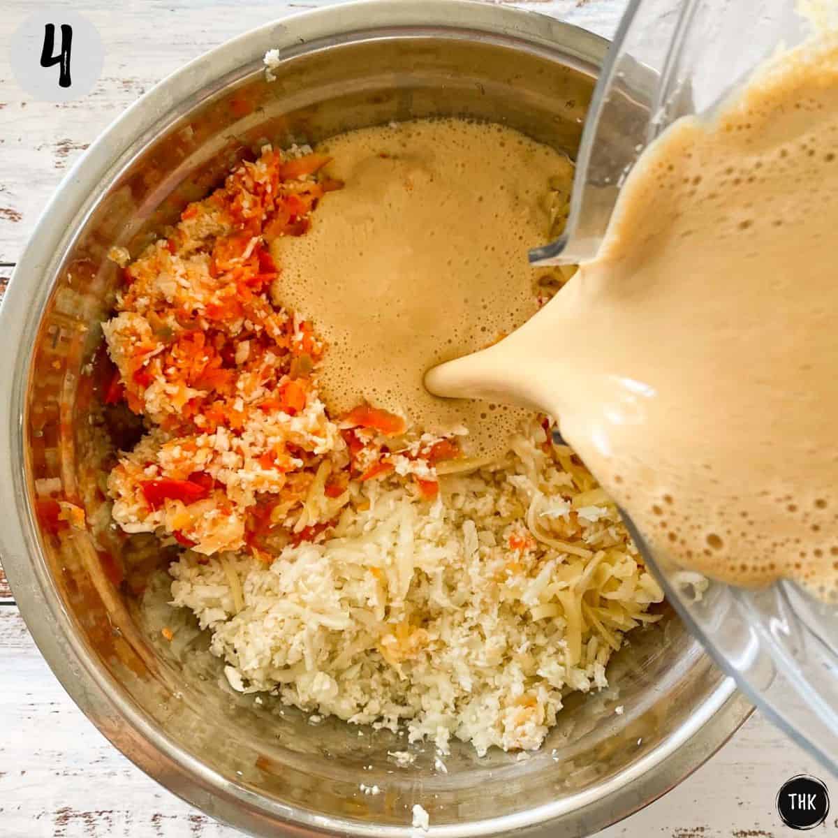 Orange sauce being poured into bowl of shredded veggies from blender spout.