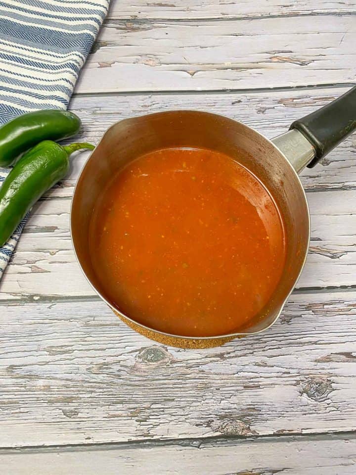 Small sauce pot filled with red sauce.
